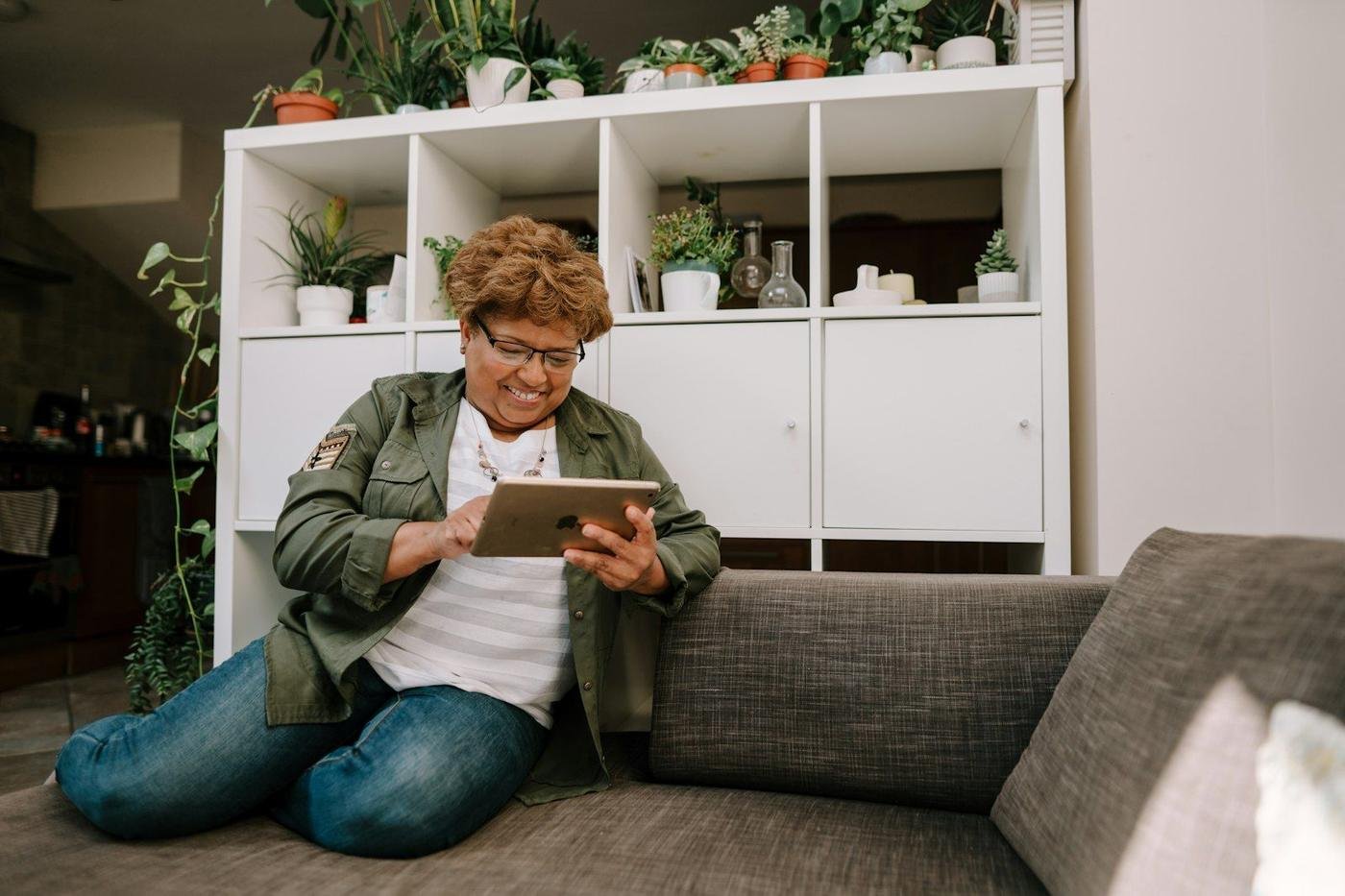 Woman sitting on the floor using a tablet at home