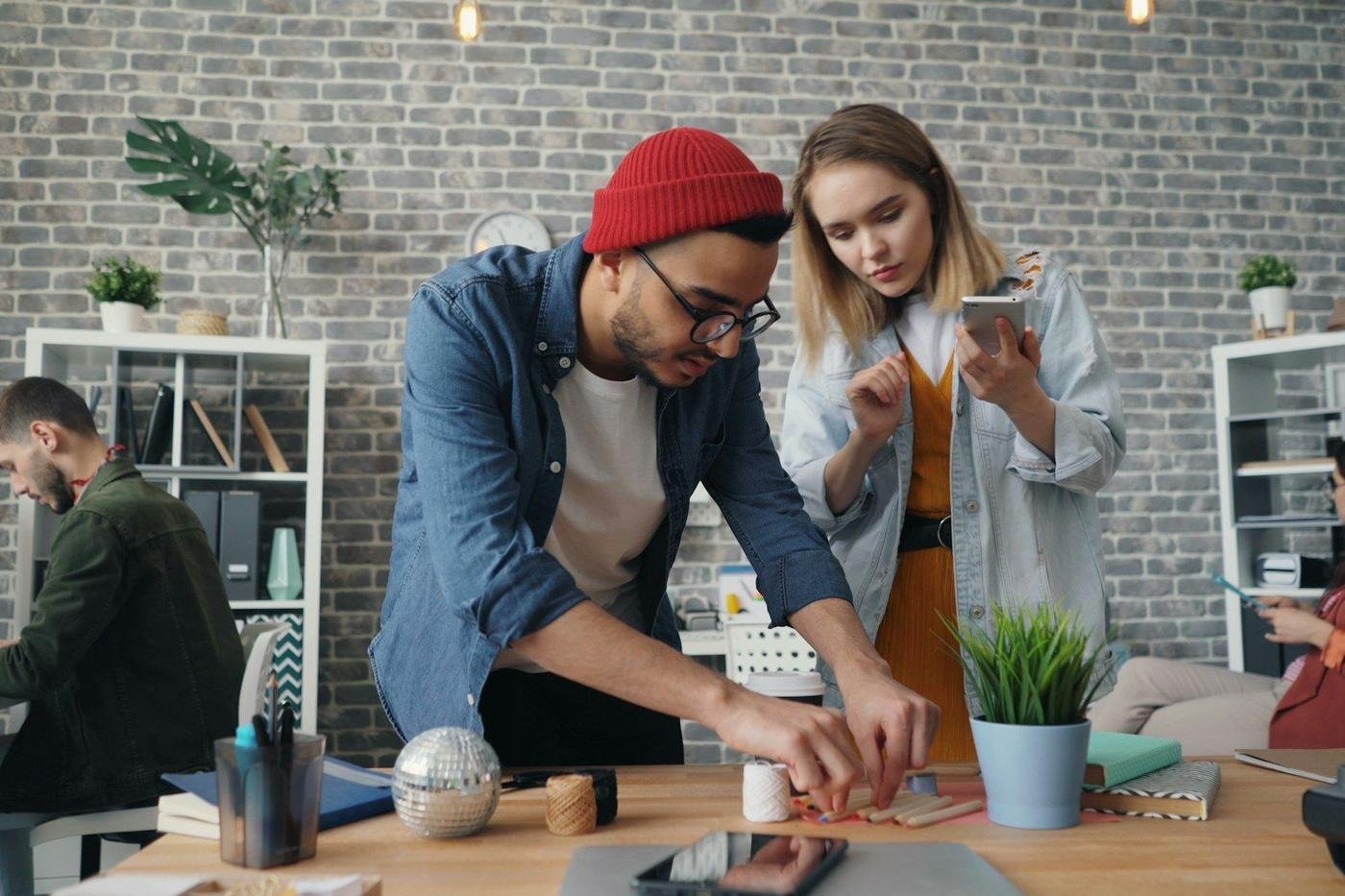 Young man and woman trying out a phone and product in a studio