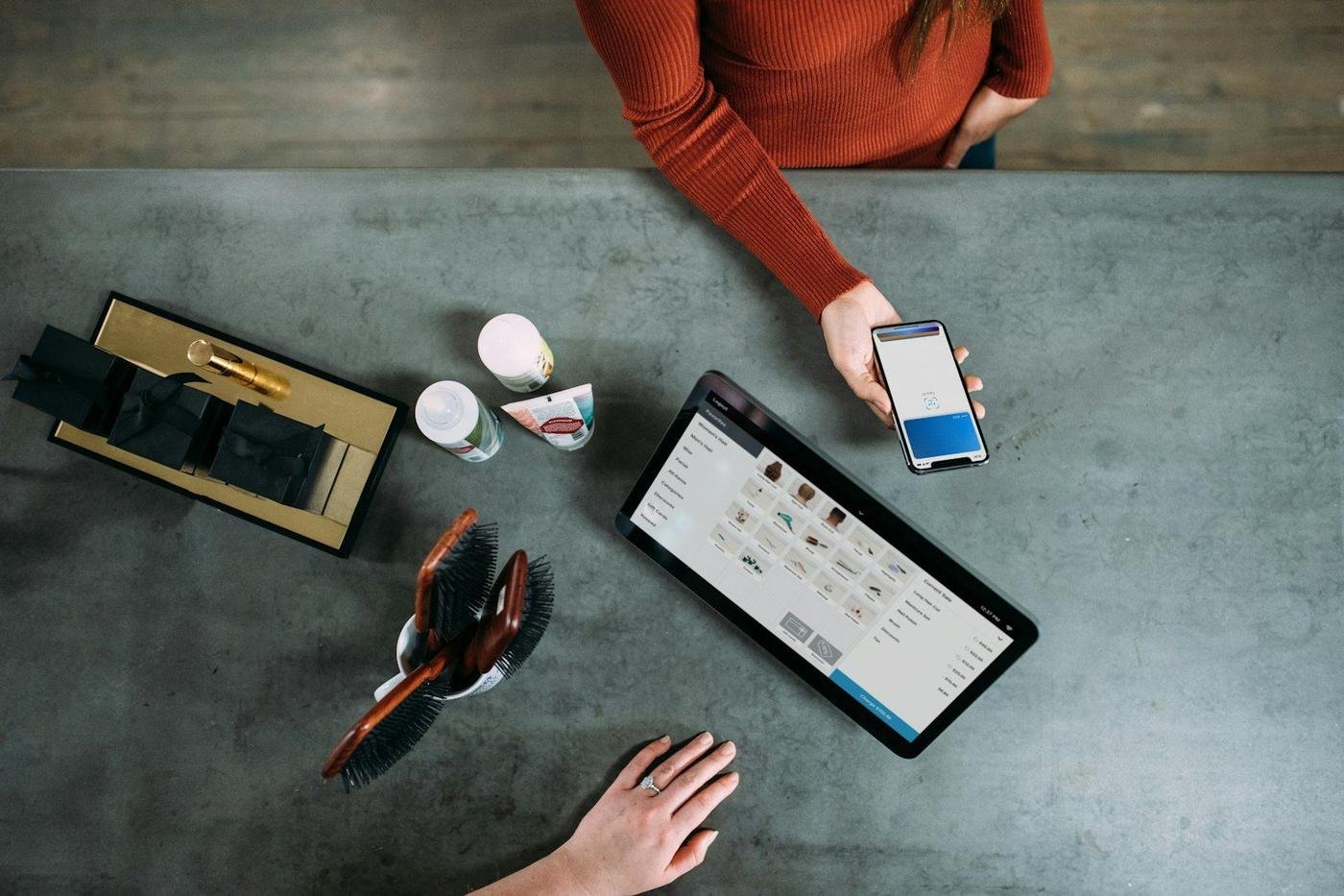 Overhead view of people using a smartphone and a tablet at a table
