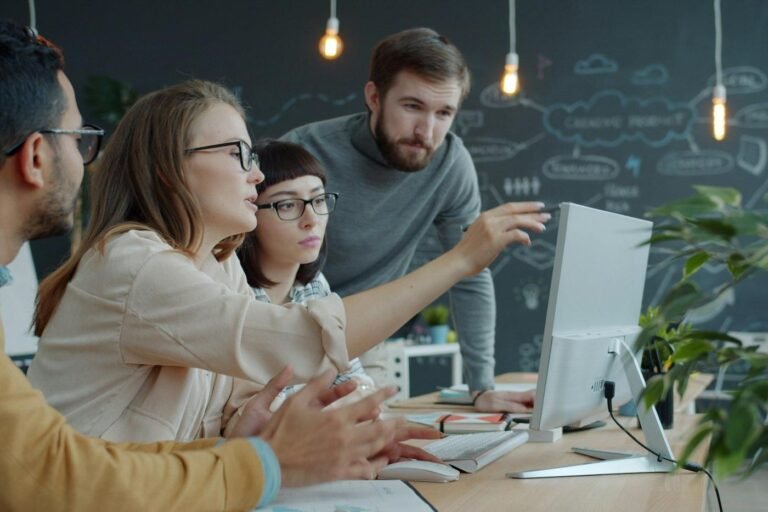 Team discussing something on a computer screen in an office