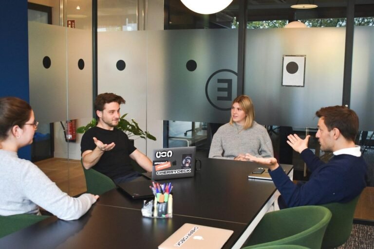 Four colleagues talking around a table in a modern office