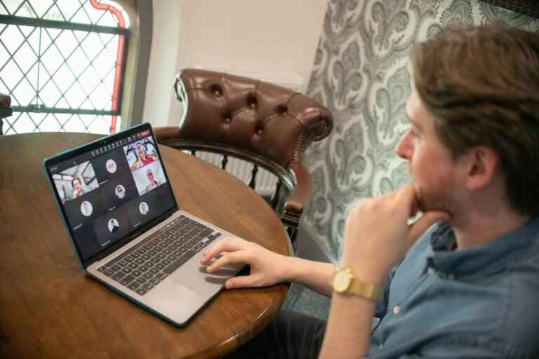 Man on a video call with several participants on his laptop